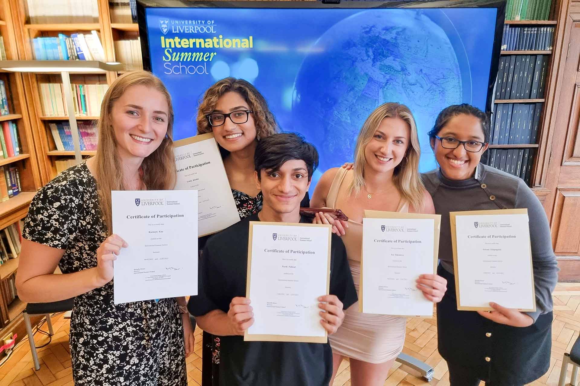 Students smiling and holding their certificates at the International Summer School's certificate event at the University of Liverpool