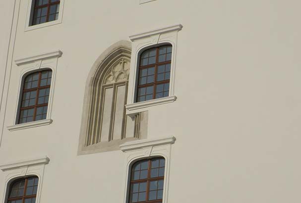 Castle windows set into a cream coloured wall
