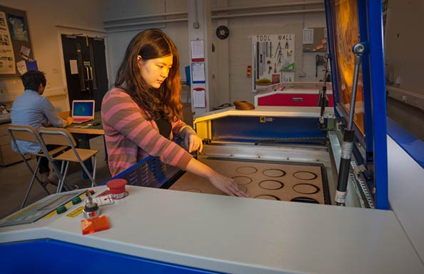 Image of student using laser cutter