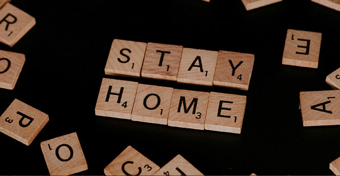 Scrabble tiles spelling 'stay home'