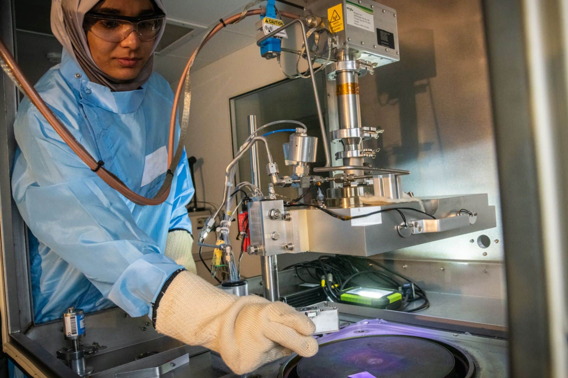 A researcher working with a piece of lab machinery