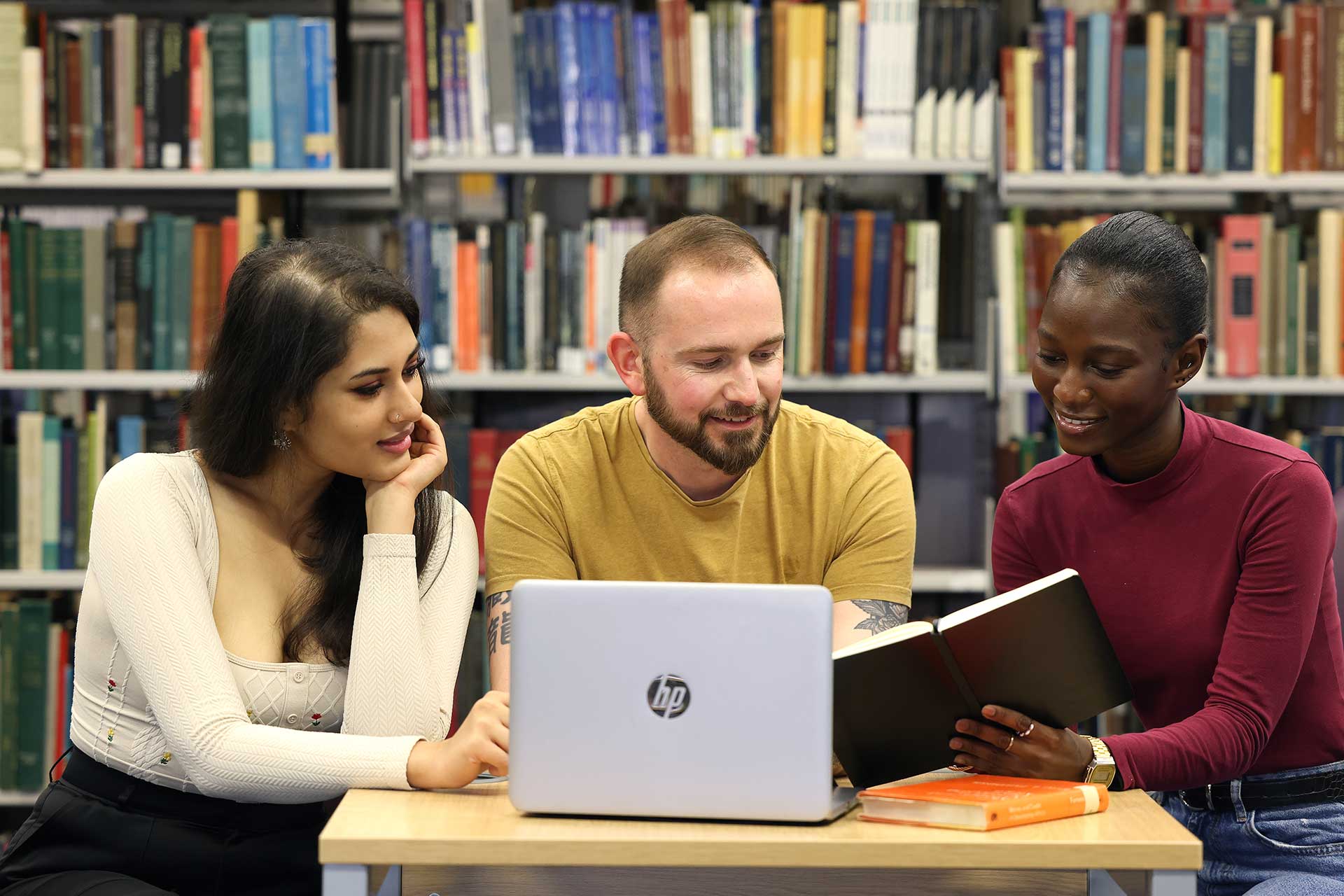 Three students studying in the library together.