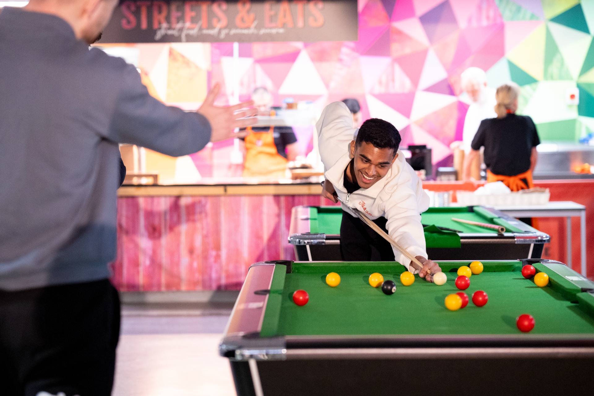 A student playing pool in the Guild.
