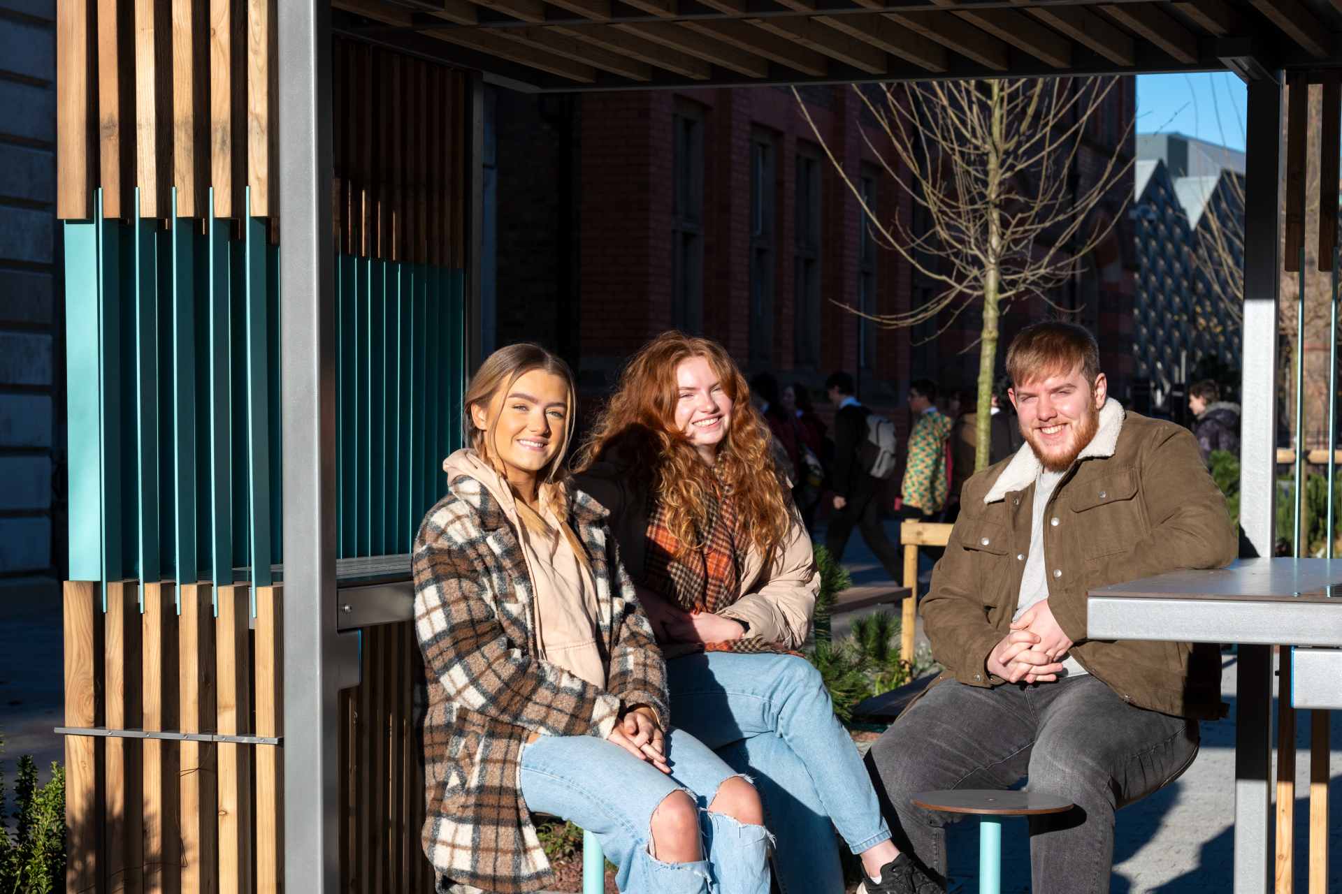 A group of students sitting in the pods outside in the sunshine.