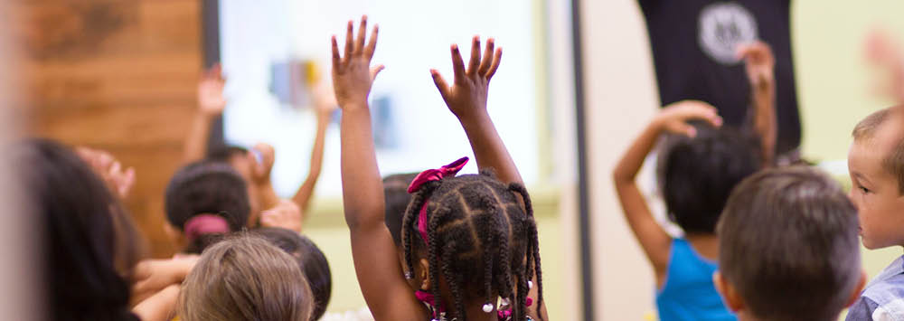 A group of children playing with their hands in the air.