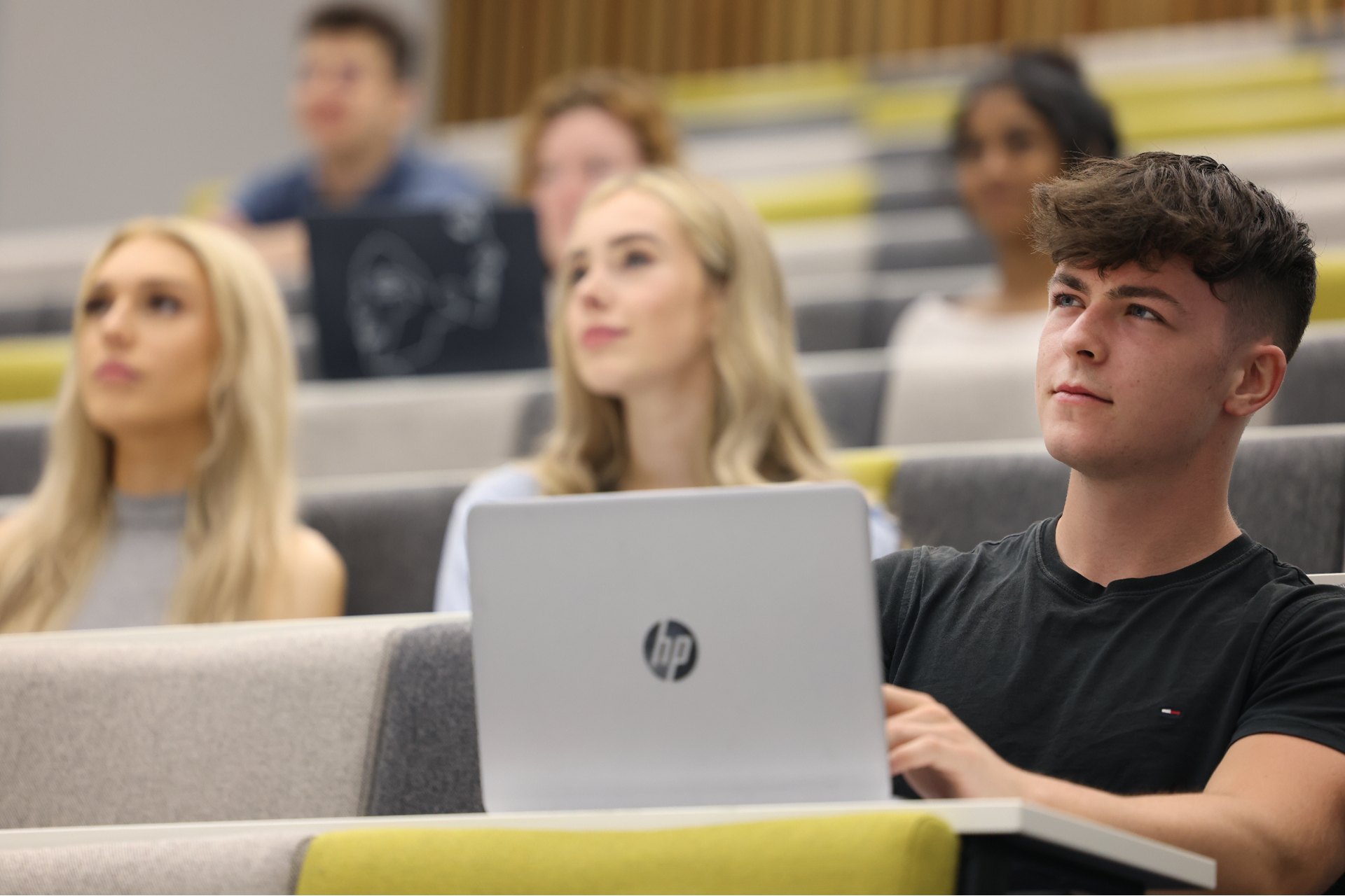 A group of students sitting in a lecture theatre.