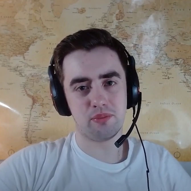 Rian smiling at camera wearing headphones and microphone with world map in background